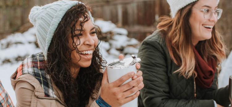 girls smiling holding hot beverage