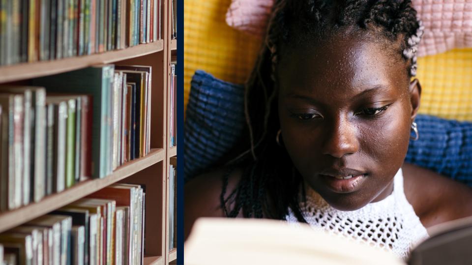 Books On A Shelf In A Library. Young black woman reading a book at home lying in the sofa