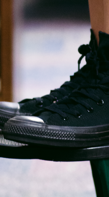 black high-top sneakers on a stool in a library