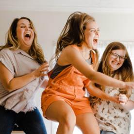 3 girls jumping and smiling