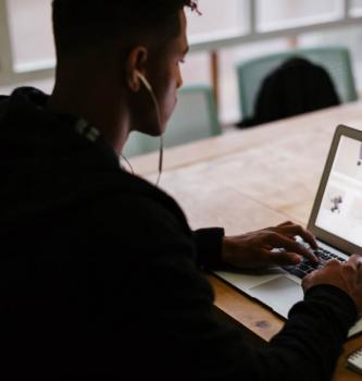 boy wearing headphones and working on a laptop